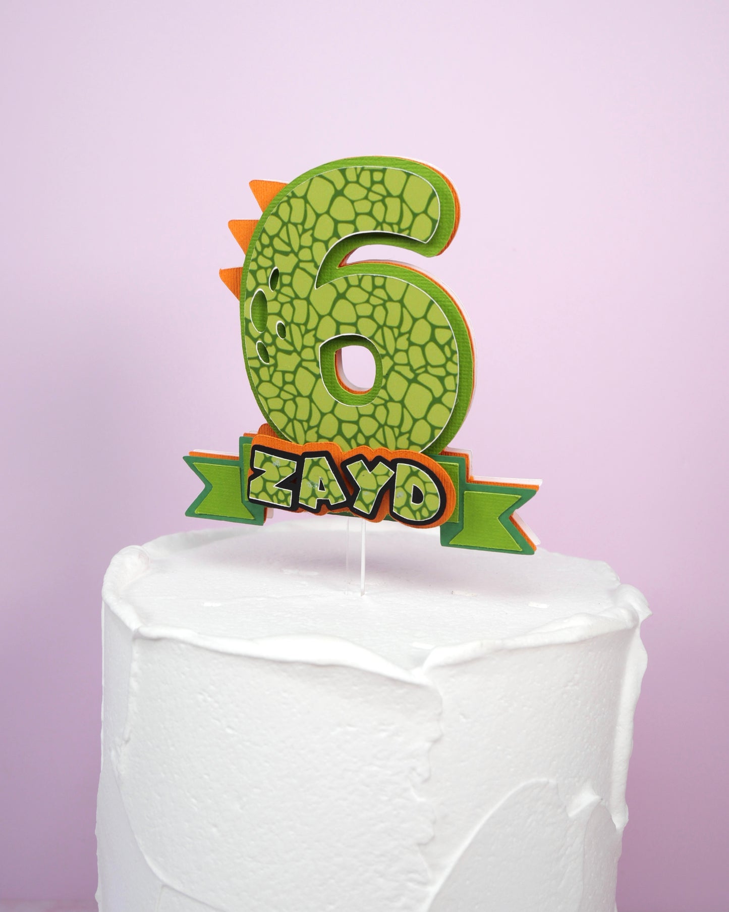 Dinosaur-themed birthday cake topper numbers 1 to 9, green and orange handmade paper designs with spikes, personalized for boys’ birthday parties.